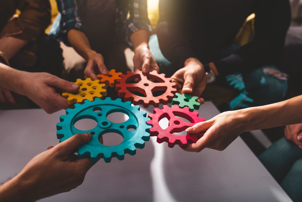 group of individuals with gears fitting them together