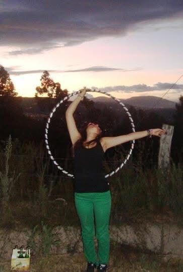 woman hoola hooping in front of a sunset