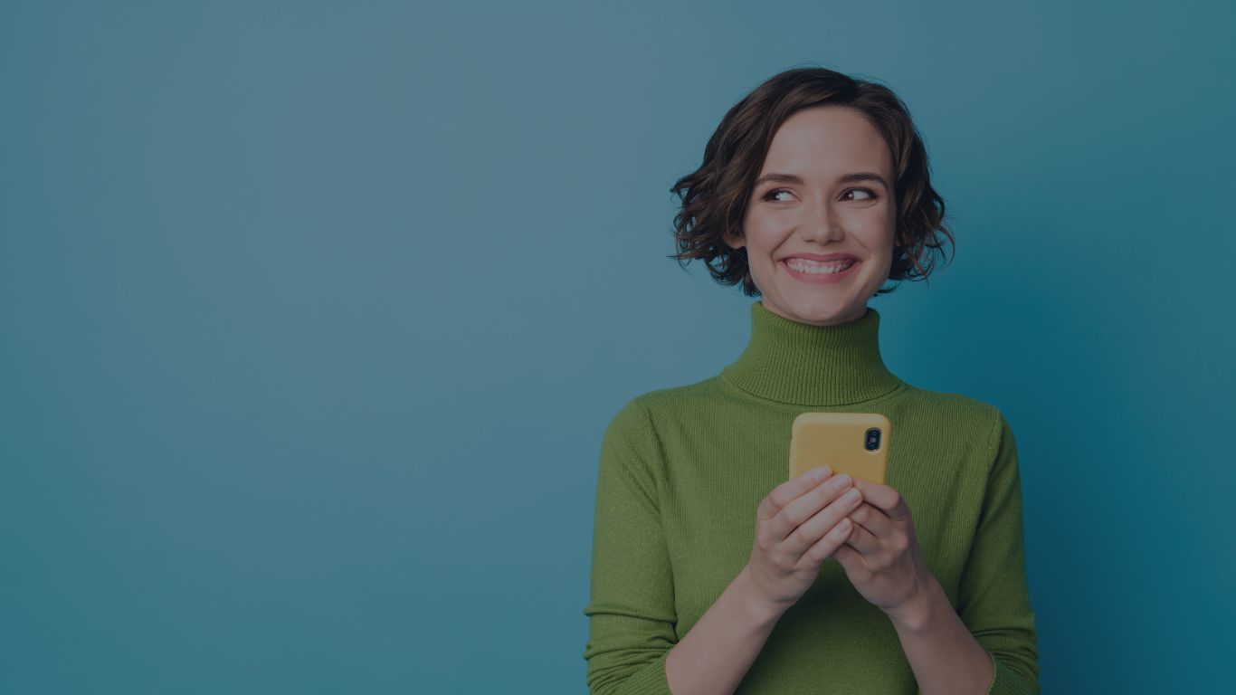 photo of a young woman on her phone looking excitedly to the right