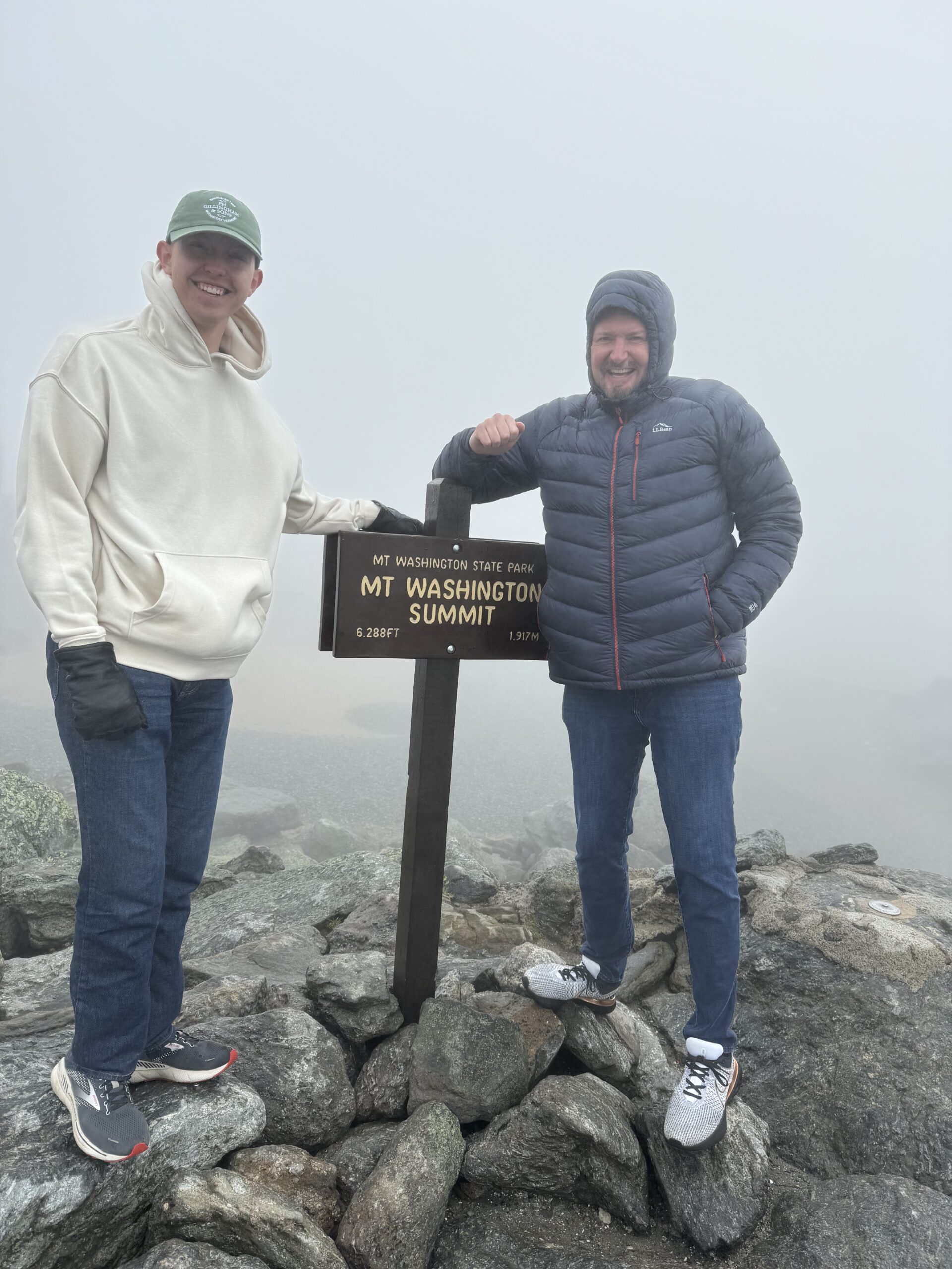 Joel and Jackson posing with the sign at the top of Mount Washington