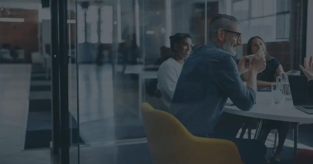 Individuals sitting around the table in a conference room.