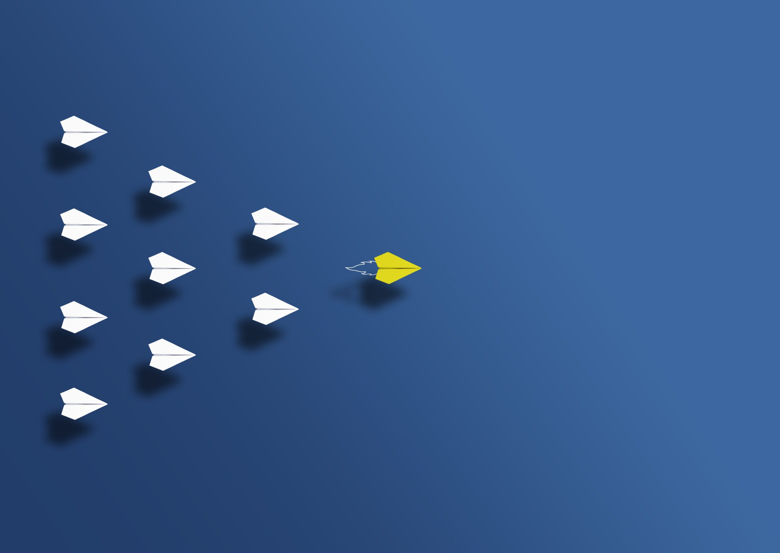 paper planes with a yellow one leading