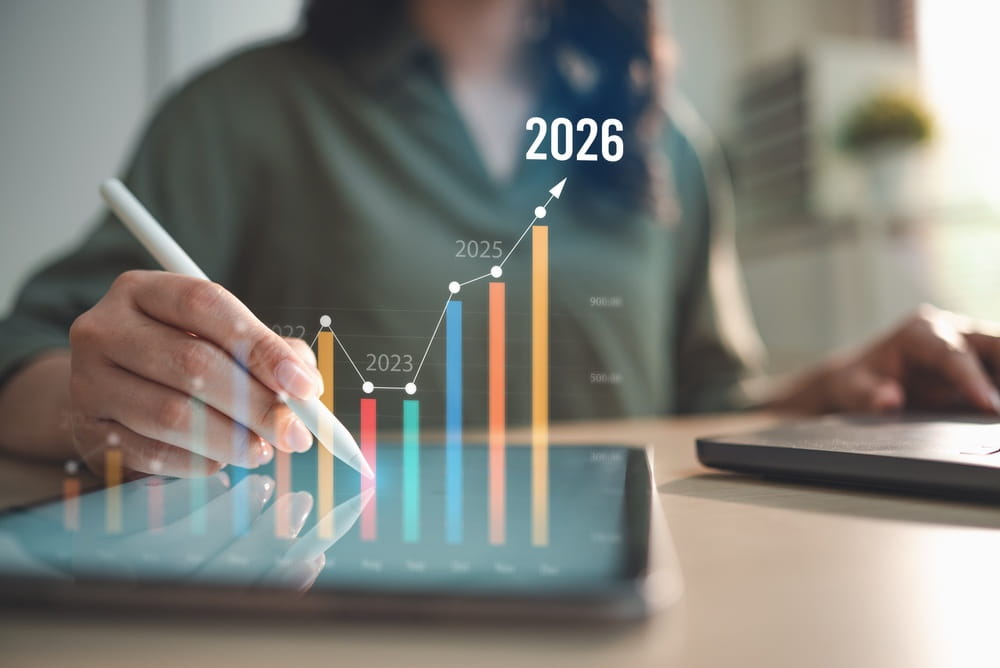 A person uses a stylus on a tablet, with a digital graph showing growth from 2023 to 2026 hovering above, indicating increasing business or financial progress—highlighting the impact of AI for Sales Leaders in optimizing pipeline focus and driving measurable success.